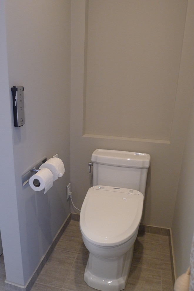 Idées déco pour un grand WC et toilettes classique en bois foncé avec un placard en trompe-l'oeil, WC à poser, un carrelage gris, des carreaux de porcelaine, un mur gris et un sol en carrelage de porcelaine.