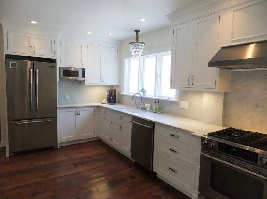 Enclosed kitchen - large transitional l-shaped medium tone wood floor enclosed kitchen idea in Indianapolis with an undermount sink, shaker cabinets, white cabinets, marble countertops, gray backsplash, stone slab backsplash, stainless steel appliances and no island