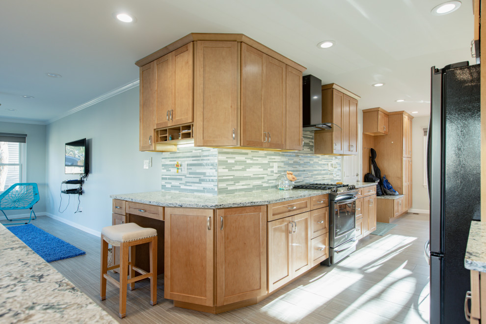 Large modern galley eat-in kitchen in DC Metro with an undermount sink, shaker cabinets, light wood cabinets, quartz benchtops, green splashback, glass tile splashback, black appliances, porcelain floors, with island, brown floor and green benchtop.