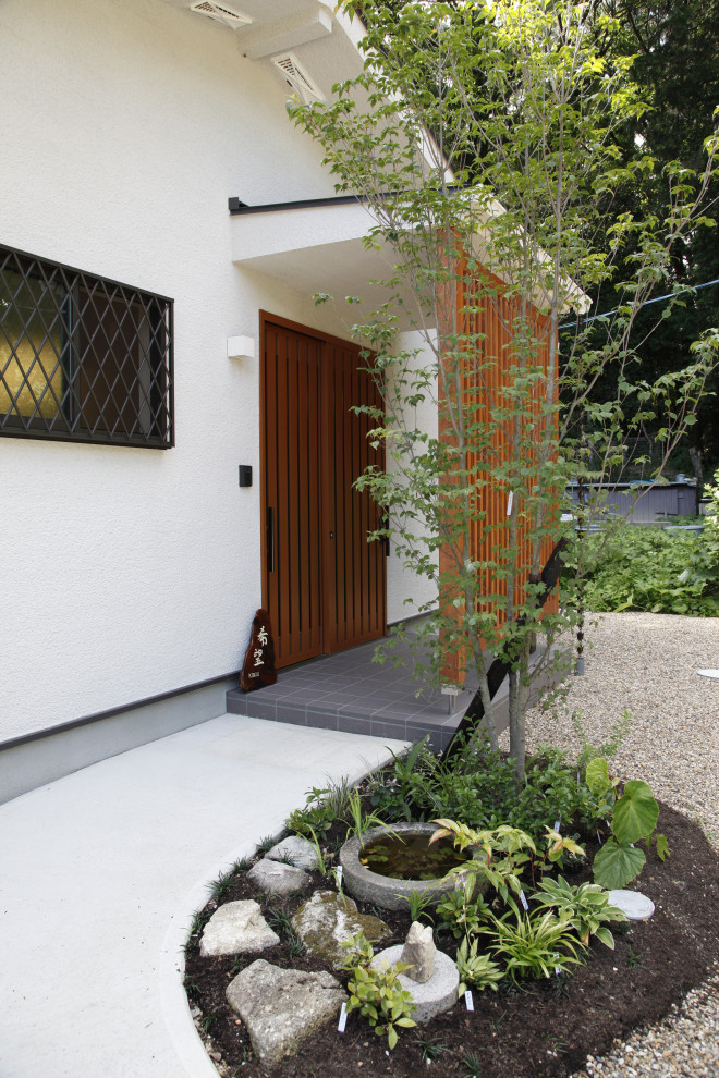 This is an example of a small scandinavian sloped full sun driveway in Kyoto with with path and concrete pavers.