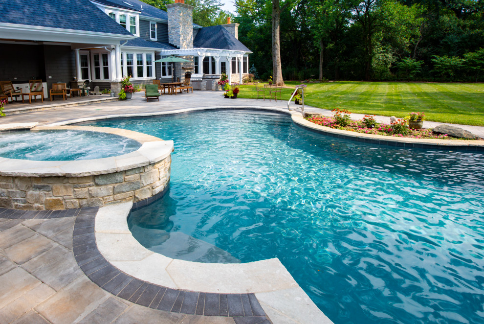 Mid-sized elegant backyard stone and custom-shaped natural hot tub photo in Chicago