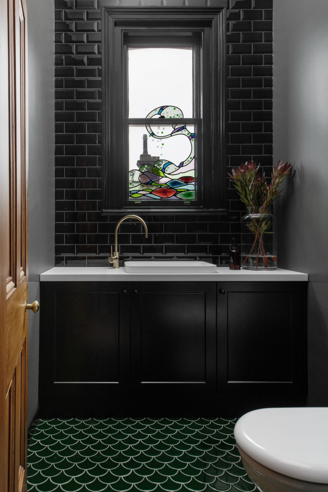 This is an example of a transitional powder room in Hobart with shaker cabinets, black cabinets, a drop-in sink, green floor and a built-in vanity.