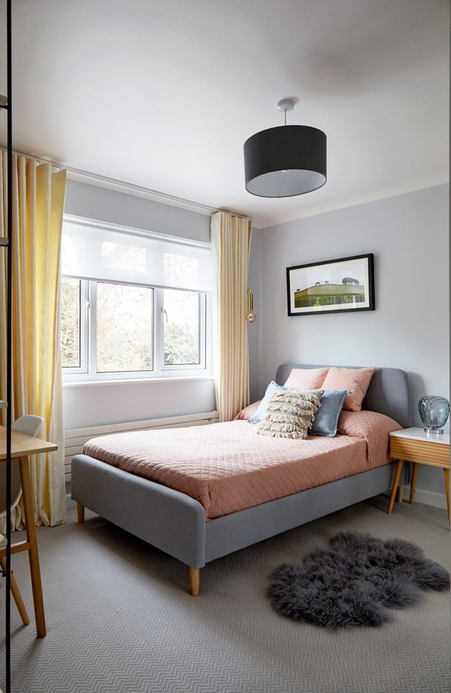Photo of a mid-sized transitional bedroom in London with grey walls, carpet and grey floor.