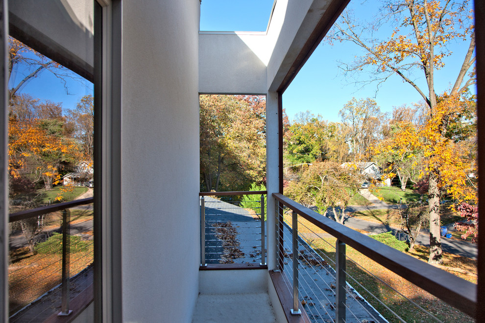 Large modern balcony in DC Metro with a roof extension, with privacy feature and mixed railing.