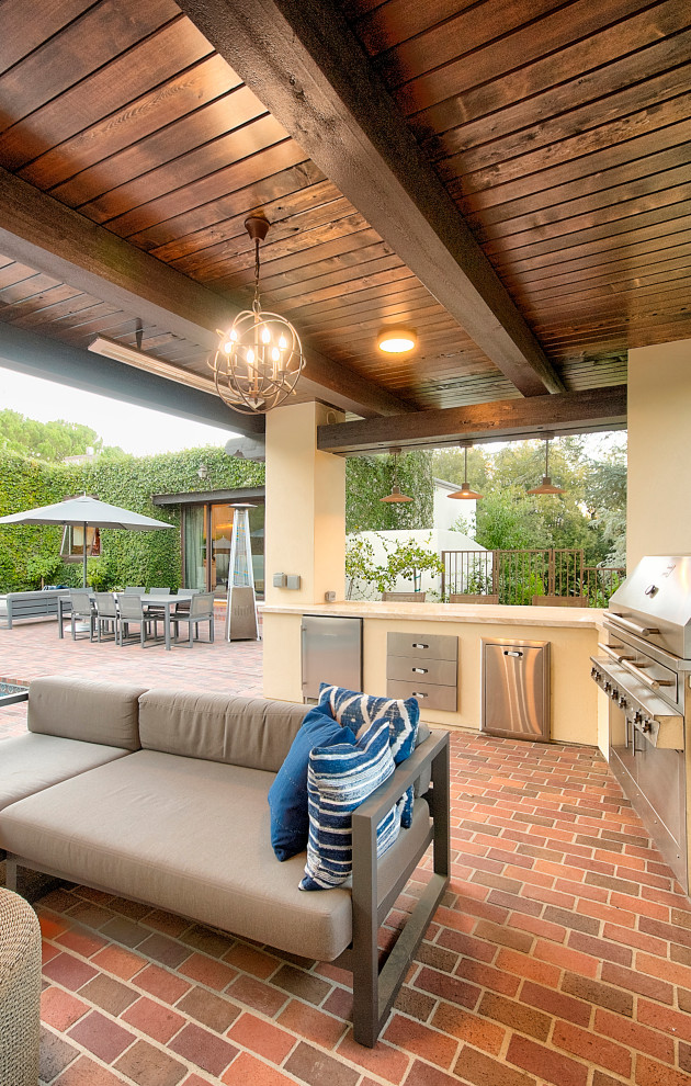 Immagine di un piccolo patio o portico eclettico dietro casa con pavimentazioni in mattoni e un gazebo o capanno