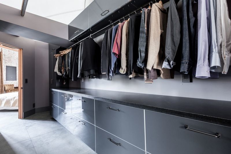 This is an example of a large modern men's walk-in wardrobe in San Francisco with flat-panel cabinets, grey cabinets, concrete floors and grey floor.