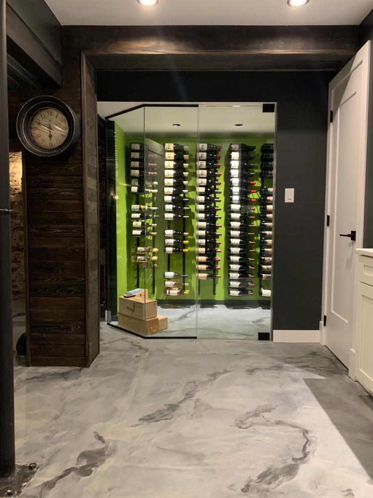 This is an example of a small eclectic wine cellar in Cincinnati with concrete floors, display racks and grey floor.