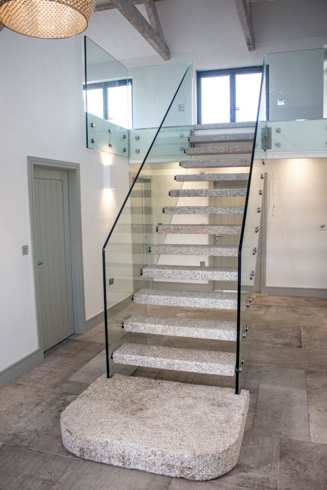 Photo of a contemporary straight staircase in Cornwall with glass risers and glass railing.