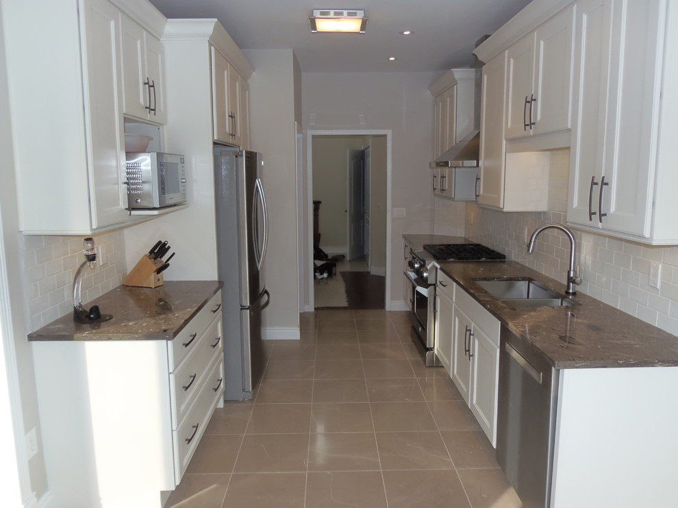 Kitchen - mid-sized transitional galley ceramic tile and beige floor kitchen idea in Toronto with a double-bowl sink, shaker cabinets, white cabinets, white backsplash, subway tile backsplash, stainless steel appliances and no island