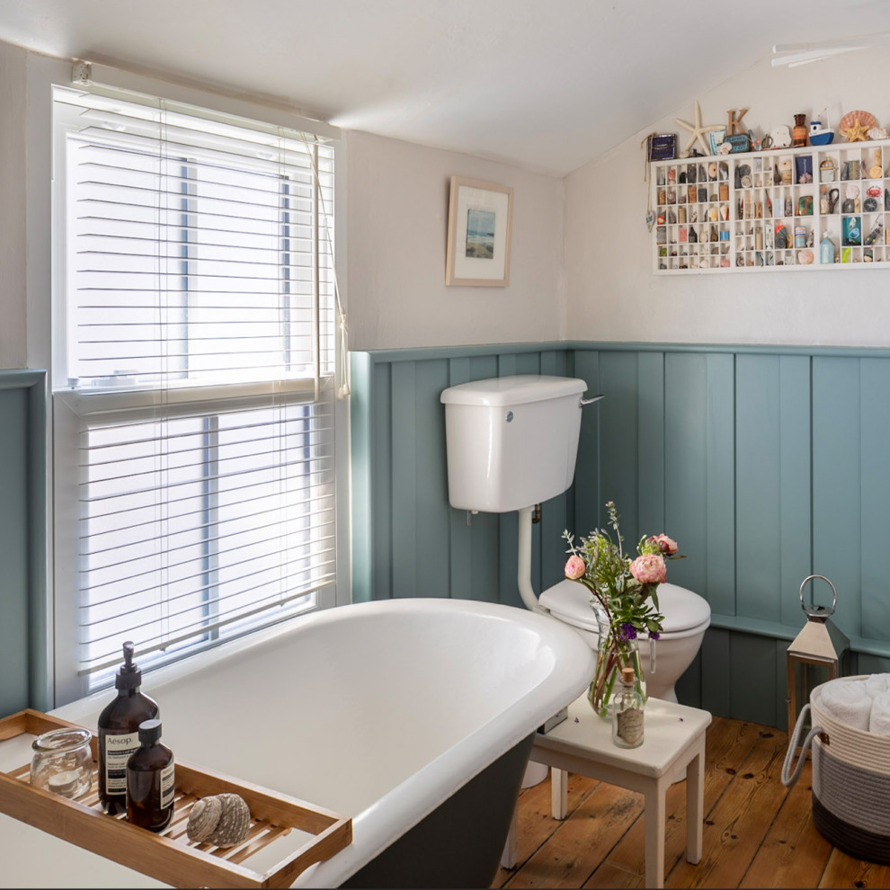 Photo of a small beach style family bathroom in Other with a claw-foot bath, light hardwood flooring and a freestanding vanity unit.