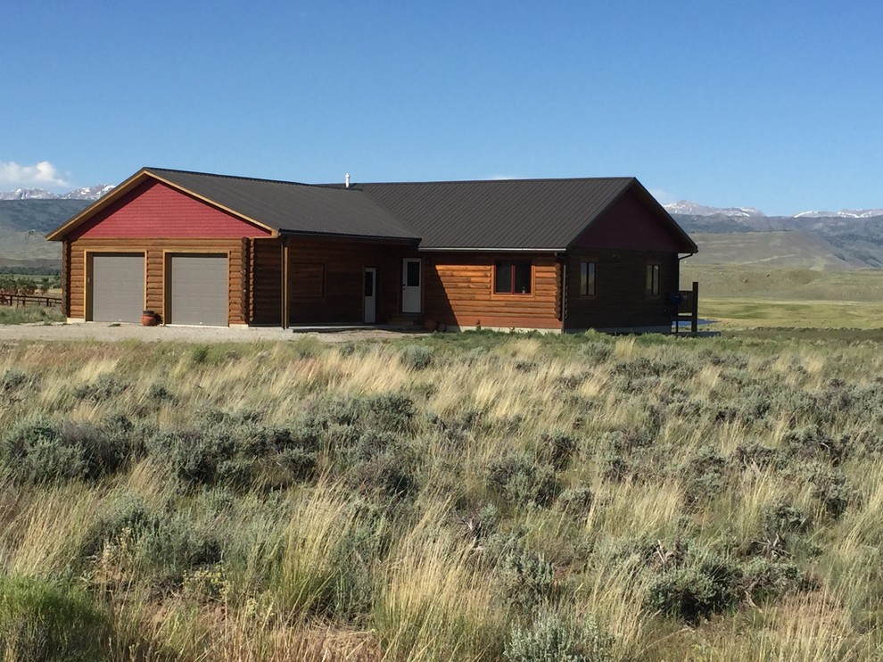 Example of a mid-sized mountain style brown one-story mixed siding gable roof design with a metal roof