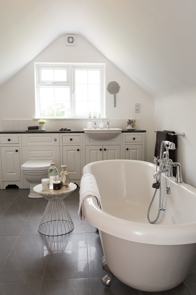 Design ideas for a beach style master bathroom in Devon with raised-panel cabinets, white cabinets, a freestanding tub, white walls and a drop-in sink.