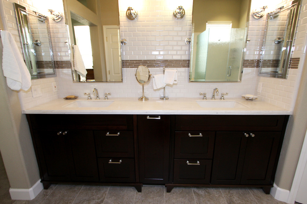 Design ideas for a mid-sized contemporary master bathroom in Sacramento with an undermount sink, shaker cabinets, dark wood cabinets, solid surface benchtops, a drop-in tub, white tile, porcelain tile and beige walls.