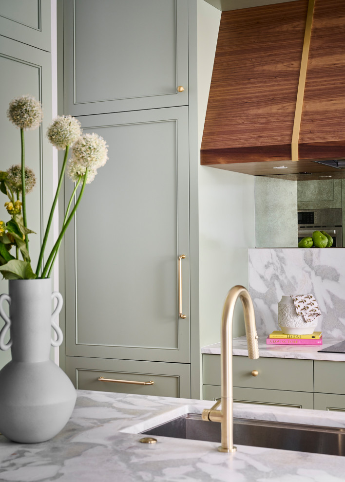 Example of a mid-sized transitional galley medium tone wood floor and brown floor open concept kitchen design in Atlanta with an undermount sink, recessed-panel cabinets, green cabinets, marble countertops, white backsplash, marble backsplash, paneled appliances, an island and white countertops