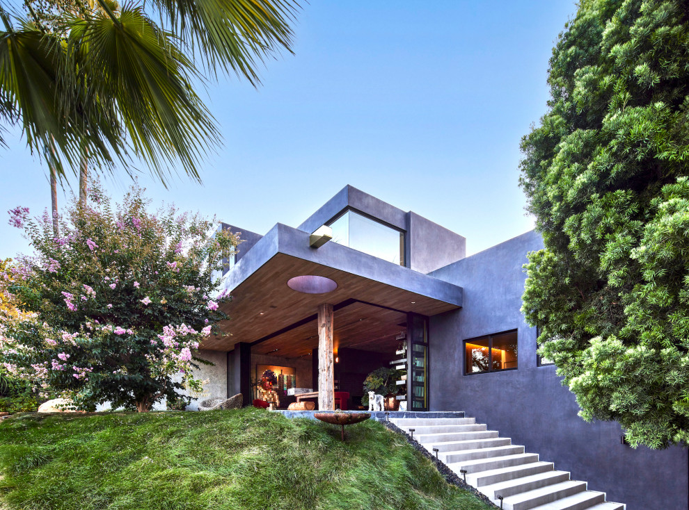 Inspiration for a large modern gray three-story stucco exterior home remodel in Los Angeles with a shingle roof and a white roof
