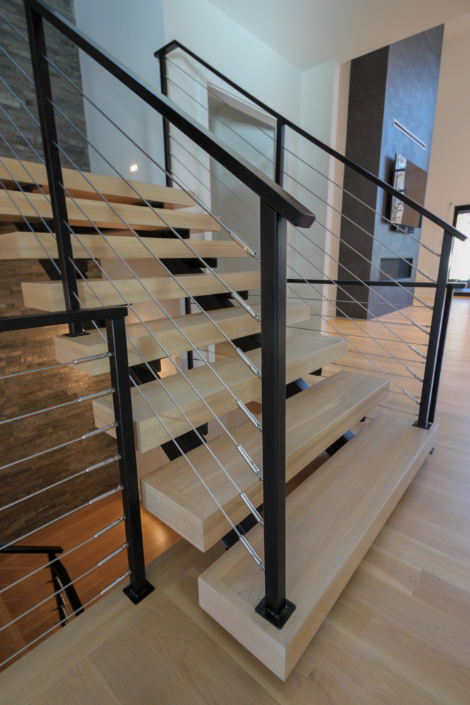 Источник вдохновения для домашнего уюта: большая лестница на больцах в стиле фьюжн с деревянными ступенями, металлическими перилами и кирпичными стенами