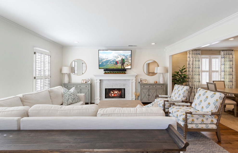 Mid-sized transitional open concept living room in Atlanta with a home bar, white walls, medium hardwood floors, a standard fireplace, a tile fireplace surround, a wall-mounted tv and brown floor.