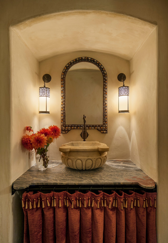 Design ideas for a mediterranean powder room in Santa Barbara with beige walls, marble benchtops and a vessel sink.