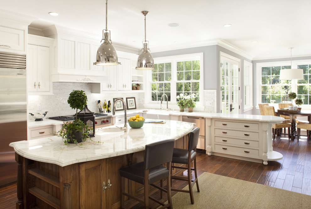 Design ideas for a large traditional l-shaped eat-in kitchen in San Francisco with stainless steel appliances, a farmhouse sink, beaded inset cabinets, white cabinets, marble benchtops, white splashback, mosaic tile splashback, medium hardwood floors and with island.