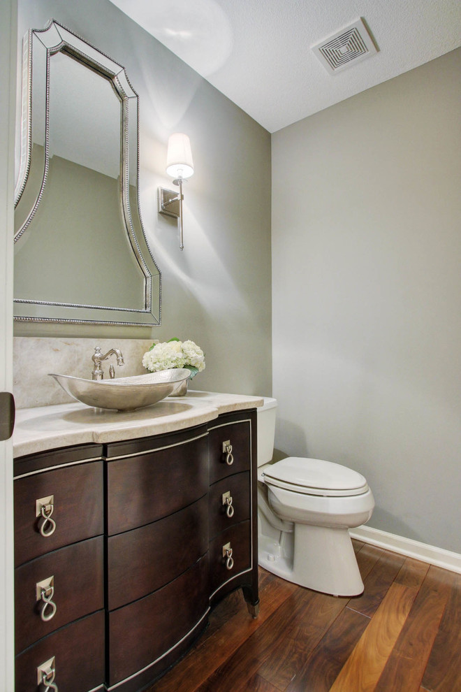 Inspiration for a mid-sized traditional powder room in Kansas City with furniture-like cabinets, dark wood cabinets, a one-piece toilet, grey walls, dark hardwood floors, a vessel sink and quartzite benchtops.