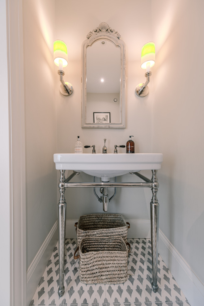 Ispirazione per un bagno di servizio classico di medie dimensioni con WC sospeso, pareti beige, pavimento in gres porcellanato, lavabo a consolle e pavimento grigio