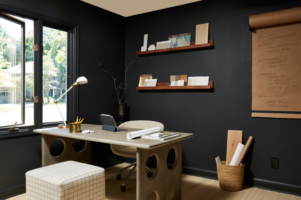 Foto di un atelier moderno di medie dimensioni con pareti nere, parquet chiaro, scrivania autoportante e pavimento beige