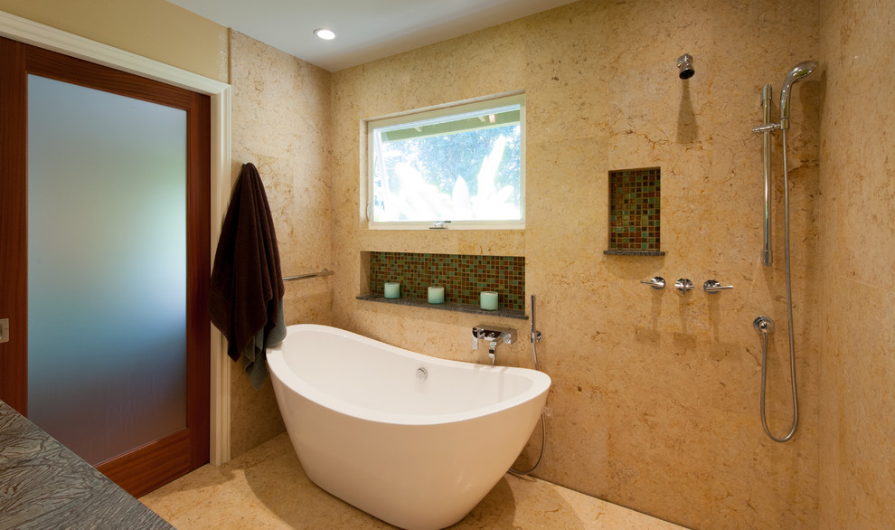 This is an example of a mid-sized contemporary master bathroom in Hawaii with flat-panel cabinets, dark wood cabinets, a freestanding tub, beige walls, soapstone benchtops, beige tile and stone slab.