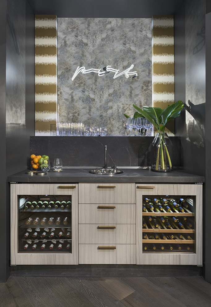 Inspiration for a small contemporary single-wall home bar in Other with flat-panel cabinets, beige cabinets, grey splashback, dark hardwood floors and brown floor.