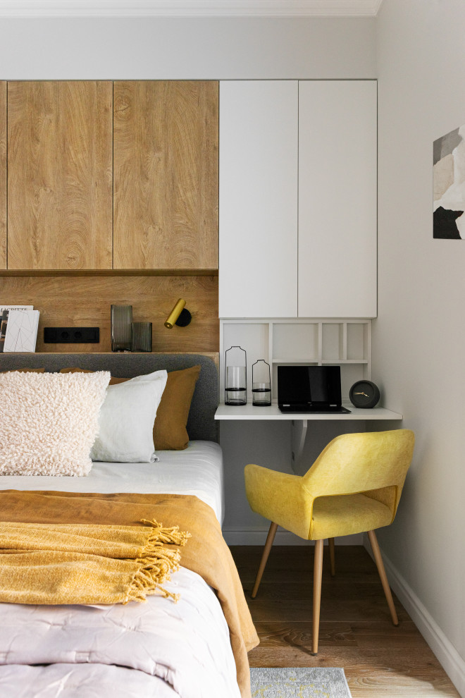 Imagen de dormitorio principal y blanco y madera actual pequeño con paredes blancas, suelo de madera en tonos medios y suelo beige