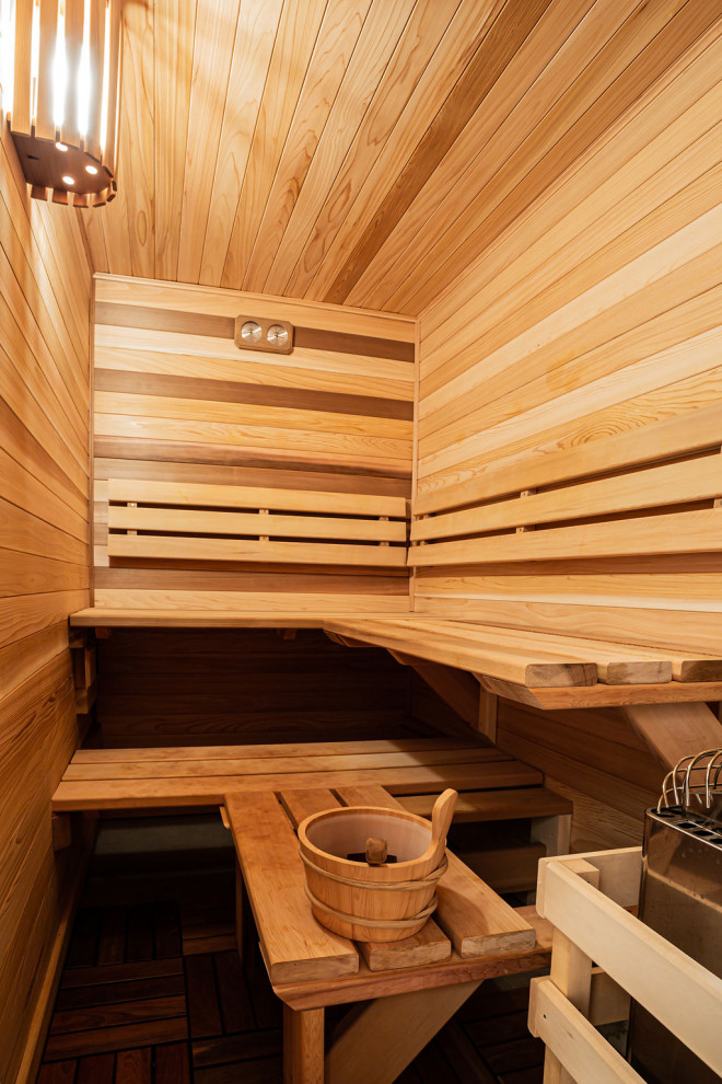 Country bathroom in Other with light hardwood floors, with a sauna, wood and wood walls.