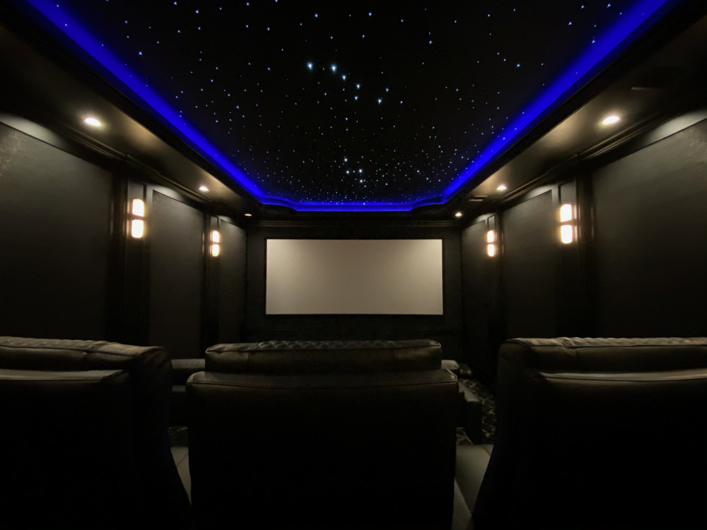 На фото: изолированный домашний кинотеатр среднего размера в современном стиле с проектором и черными стенами с