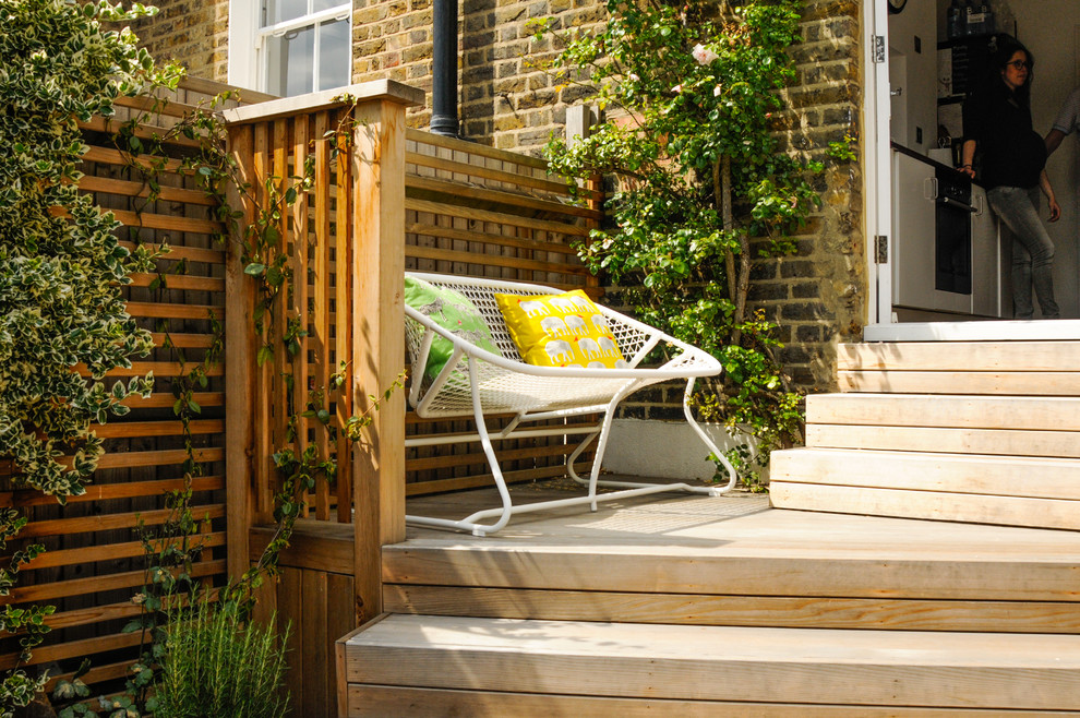Inspiration for a small contemporary backyard partial sun garden in London with decking.