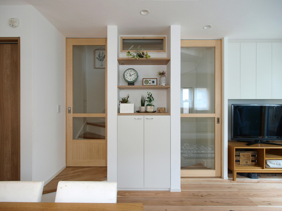 Scandinavian open concept living room in Tokyo with white walls, light hardwood floors and beige floor.