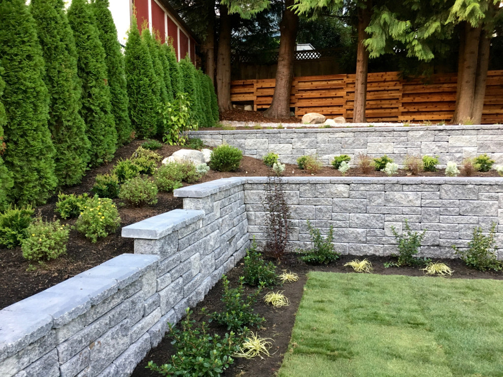 Mid-sized modern backyard partial sun garden in Vancouver with a retaining wall.