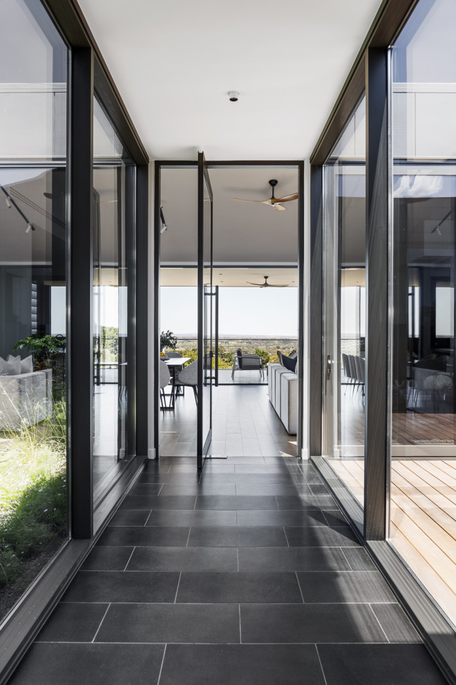Design ideas for a mid-sized contemporary hallway in Melbourne with black walls and panelled walls.