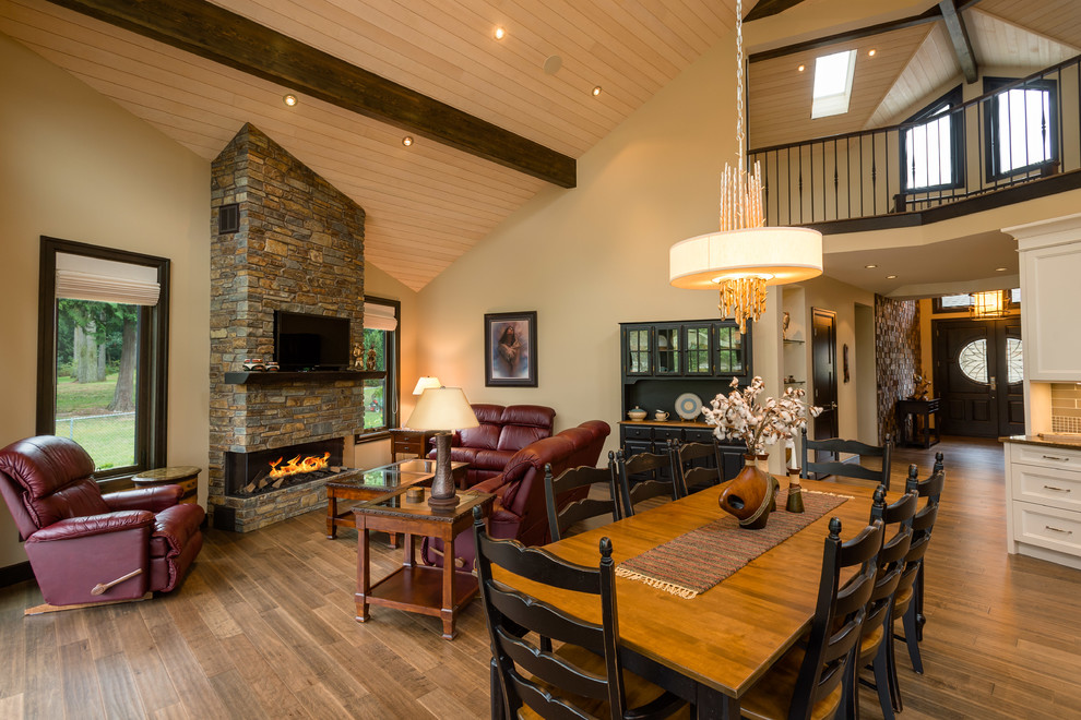 Inspiration for a large country open plan dining in Vancouver with beige walls, medium hardwood floors, a standard fireplace and a brick fireplace surround.