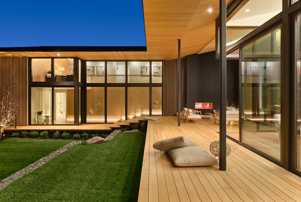 Inspiration for an expansive contemporary backyard deck in Portland with a roof extension.
