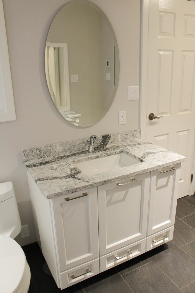 Photo of a large traditional master bathroom in Vancouver with shaker cabinets, white cabinets, an alcove tub, a corner shower, a one-piece toilet, gray tile, porcelain tile, grey walls, porcelain floors, an undermount sink and engineered quartz benchtops.