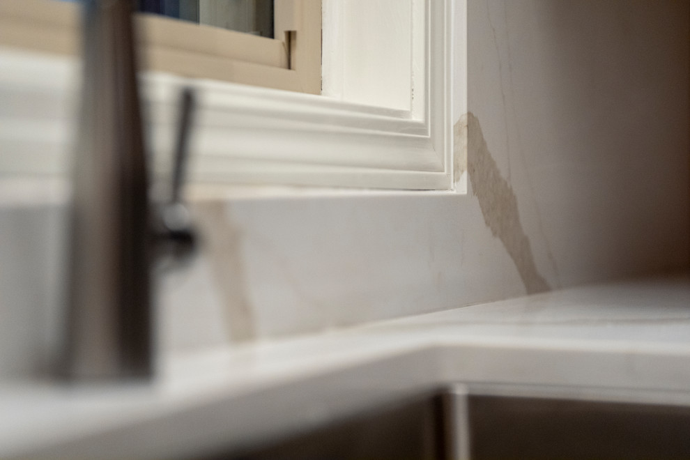 Inspiration for a large transitional l-shaped medium tone wood floor and brown floor eat-in kitchen remodel with a single-bowl sink, shaker cabinets, medium tone wood cabinets, quartz countertops, white backsplash, quartz backsplash, stainless steel appliances, an island and white countertops