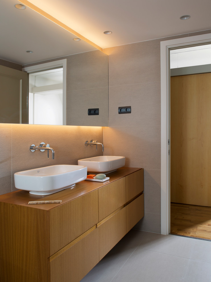 Inspiration for a mid-sized modern master wet room bathroom in Barcelona with shaker cabinets, medium wood cabinets, a one-piece toilet, beige tile, beige walls, a vessel sink, wood benchtops, grey floor and a sliding shower screen.