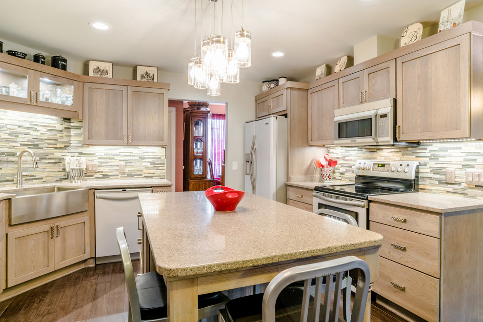 Inspiration for a mid-sized transitional u-shaped medium tone wood floor enclosed kitchen remodel in Miami with a farmhouse sink, shaker cabinets, gray cabinets, quartz countertops, gray backsplash, glass tile backsplash, white appliances and an island
