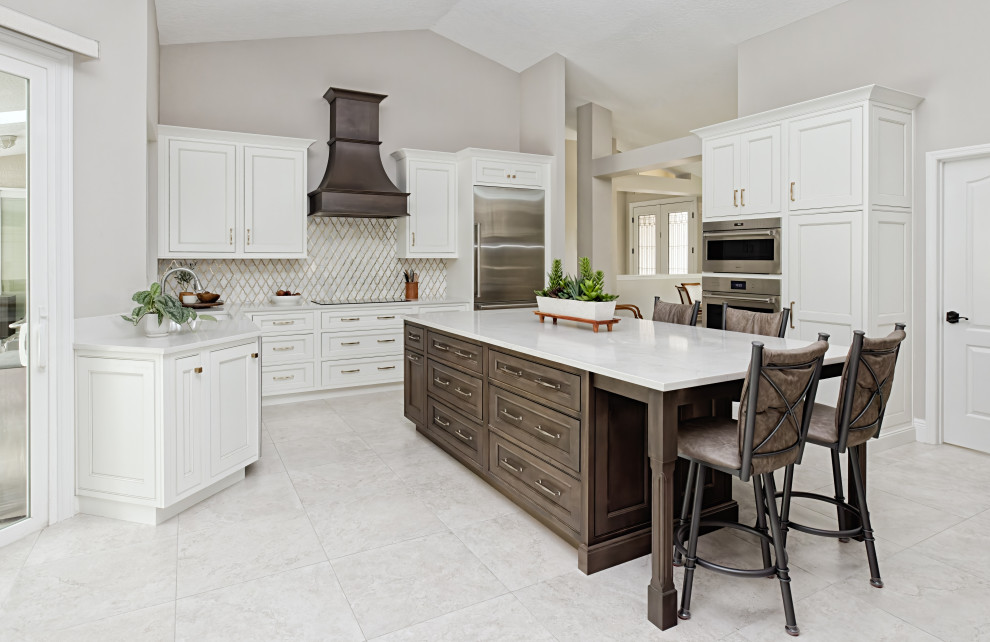 Transitional u-shaped eat-in kitchen in Orlando with an undermount sink, beaded inset cabinets, white cabinets, quartz benchtops, white splashback, porcelain splashback, porcelain floors, with island and white benchtop.