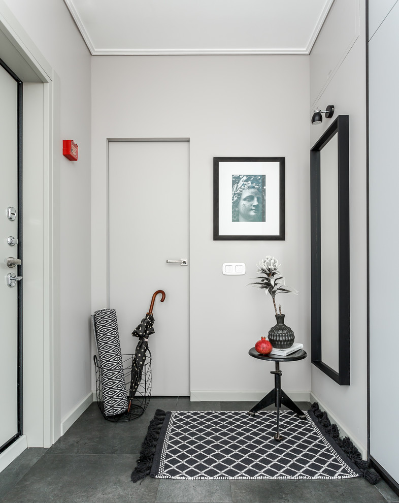 Inspiration for a contemporary vestibule in Moscow with white walls, a single front door, a white front door and grey floor.