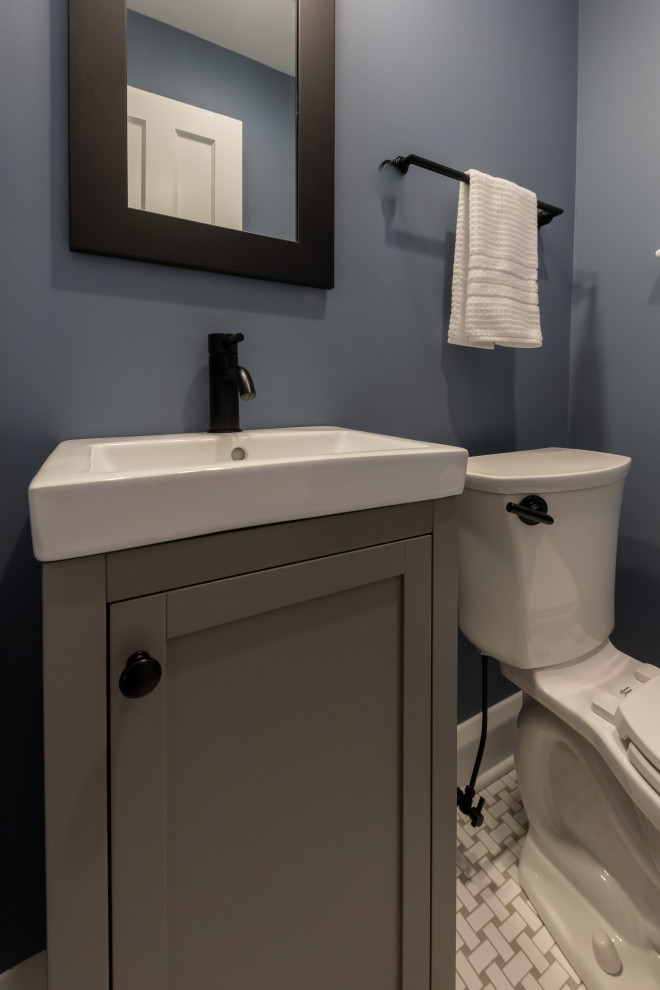 Aménagement d'un petit WC et toilettes classique avec un placard à porte shaker, des portes de placard grises, WC séparés, un mur bleu, un sol en carrelage de terre cuite, un sol gris, un plan de toilette blanc et meuble-lavabo sur pied.