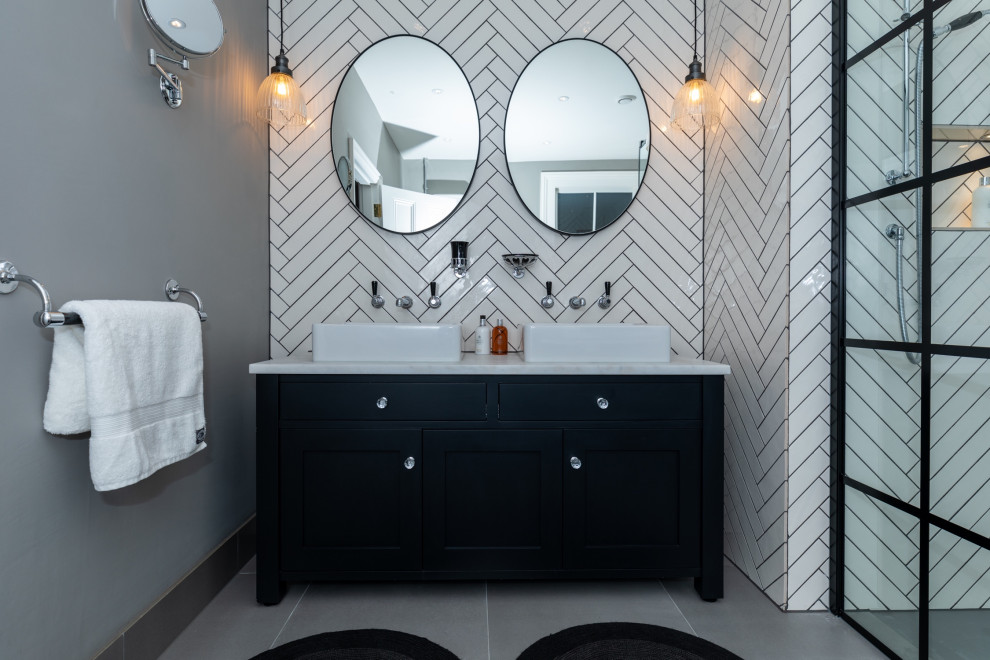 Design ideas for a large transitional 3/4 bathroom in Surrey with shaker cabinets, black cabinets, a corner shower, white tile, porcelain tile, grey walls, porcelain floors, a vessel sink, grey floor, white benchtops, a double vanity and a freestanding vanity.