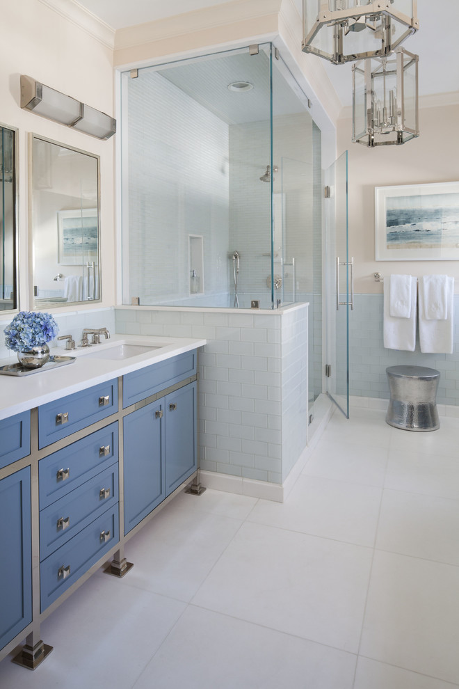 Design ideas for a transitional master bathroom in Dallas with an undermount sink, shaker cabinets, blue cabinets, a corner shower, blue tile, glass tile, pink walls, marble floors, white floor, a hinged shower door and white benchtops.