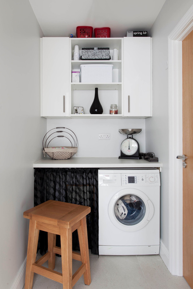 Inspiration for a small transitional laundry room in Dublin with multi-coloured splashback, stone slab splashback, ceramic floors, open cabinets, white cabinets and white walls.