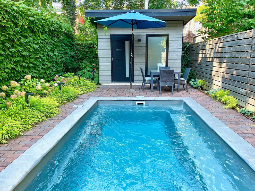 This is an example of a mid-sized eclectic full sun backyard concrete paver and wood fence flower bed in Toronto.