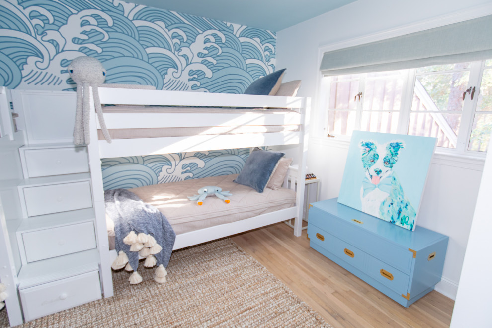 На фото: большая нейтральная детская в морском стиле с спальным местом, синими стенами, светлым паркетным полом и обоями на стенах для ребенка от 4 до 10 лет с