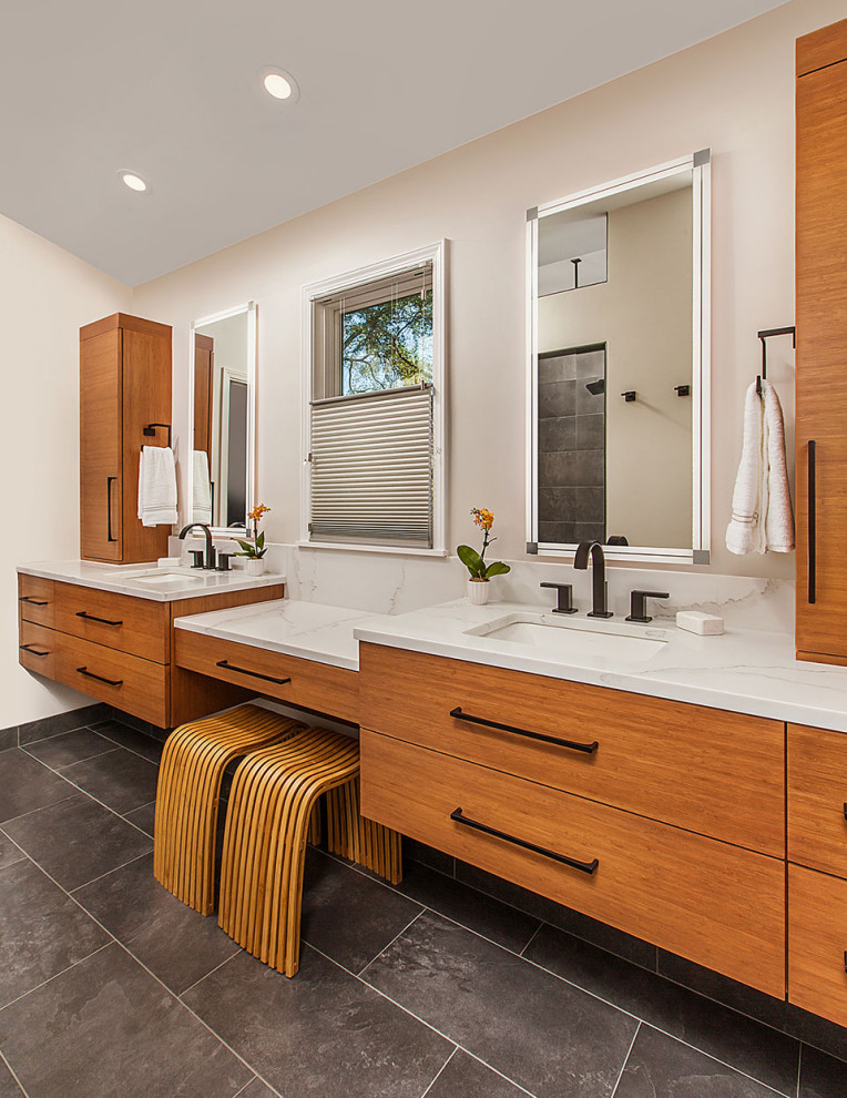 Mid-sized master gray tile and porcelain tile ceramic tile, gray floor and double-sink bathroom photo in Detroit with flat-panel cabinets, medium tone wood cabinets, an undermount tub, a bidet, beige walls, an undermount sink, quartz countertops, white countertops, a niche and a floating vanity